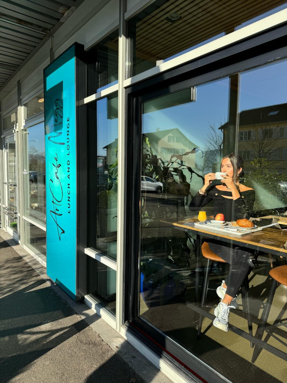 Gast mit Kaffee und Frühstück am Fenster des ArtCafé Megg in Meggen